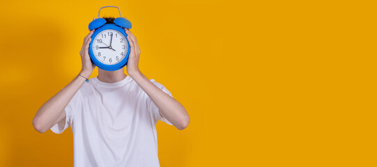 isolated boy or teenager with clock in front of face