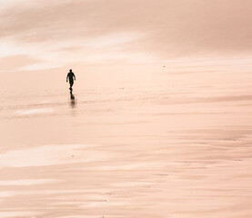 silhouette of a person walking on the beach