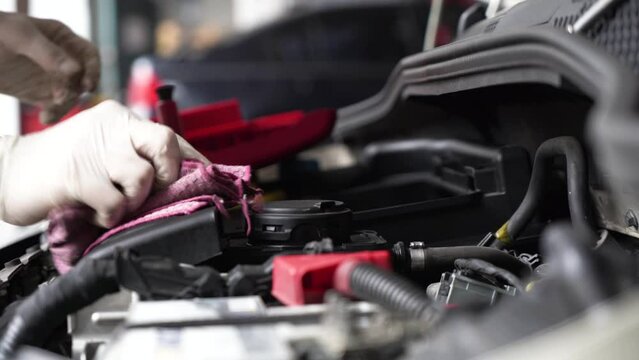 An auto mechanic is cleaning the engine compartment. car service. close-up.