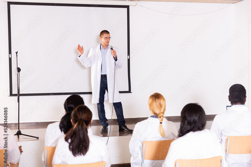 Canvas Prints Portrait of confident male medical coach giving speech at conference for health workers