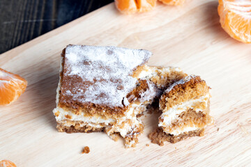 a piece of honey cake with vanilla cream and citrus tangerines