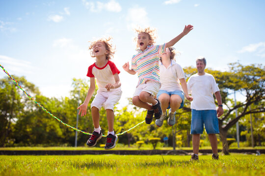 Happy Kids Play Outdoor. Children Skipping Rope.