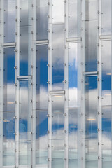 Reflection of blue sky and white clouds in a shiny wall, as a graphic background

