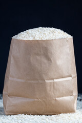 a pile of white rice in a paper bag and on the table
