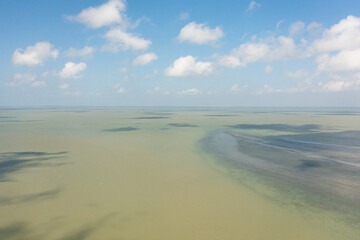 Blue ocean with waves and sky with clouds, seascape top view. Blue sea water with waves against sky. Summer and travel vacation concept.