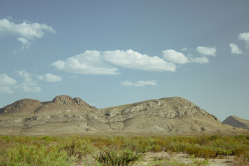 Vintage looking mountain range in desert with clouds