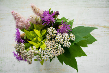 Close-up of a bouquet of wild flowers on a wooden background. Rustic style