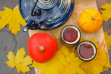 Autumn tea.Tea drinking.teapot and two striped cups in the garden on a sunny autumn day.mugs with...