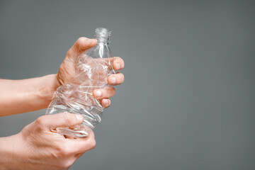 Crumpled bottle pet plastic resize or zero waste plastic hand recycling garbage crush. Raised hands holding crumpled plastic bottle hand squeeze bottle water plastic recycle reuse reduce waste concept