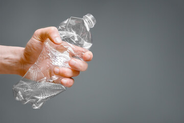 Crumpled bottle pet plastic resize or zero waste plastic hand recycling garbage crush. Raised hands holding crumpled plastic bottle hand squeeze bottle water plastic recycle reuse reduce waste concept