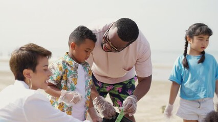 4K Group of Diversity family on summer holiday vacation. Parents teaching children kid picking up plastic bottle and garbage on the beach. Environment protection volunteer and waste pollution concept