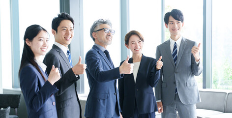 親指を立てて応援するアジア人のビジネスパーソン