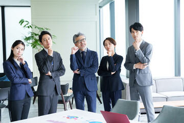 考え事をするアジア人のビジネスパーソン