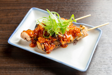 食べるラー油をトッピングした鶏肉の串焼き