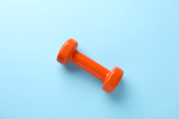 Stylish dumbbell on light blue background, top view