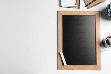 Flat lay composition with small chalkboard on white background, space for text