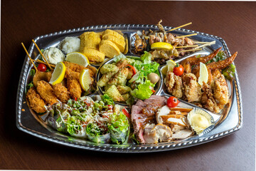 居酒屋やホームパーティー向けに提供される、ローストビーフ、鶏の唐揚げ、手羽先、串カツ、出し巻き卵などを贅沢に盛り合わせたオードブル。大人数での宴会やイベントを華やかに彩る、ボリューム満点のパーティープレート © Photo Craft