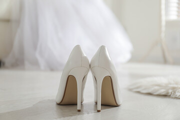White wedding shoes on floor in room, back view