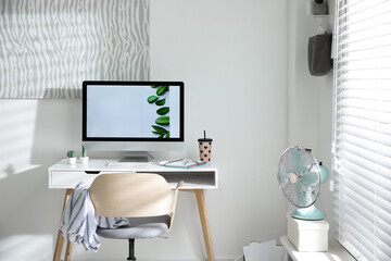 Comfortable office chair near desk with modern computer indoors