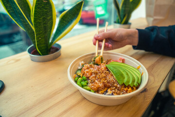 Eating poke bowl with chopsticks