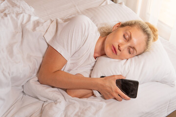 Woman blonde phone beautiful sleep mobile bed blanket sleeping lying, for white relax from person from home nap, comfortable healthy. Indoors serene day,