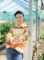 Portrait of asian positive woman in greenhouse on sunny day