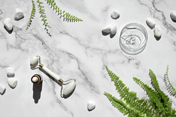 Self made moisturizer, essential oil and green jade face roller. Exotic fern leaves on off white...