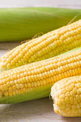 Fresh ripe yellow cobs corn on wooden table