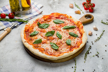 Italian pizza Margherita with cheese, tomato sauce and basil on the board on grey table, Margarita