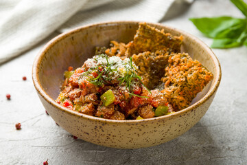 Tuna tar tar with avocado on bowl on grey table macro close up