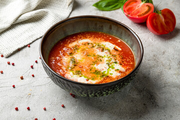 Soup cream of tomato on bowl on grey table