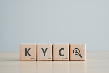 KYC on wooden cubes. know your customer with magnifying glass. Business verifying the identity of its clients concept