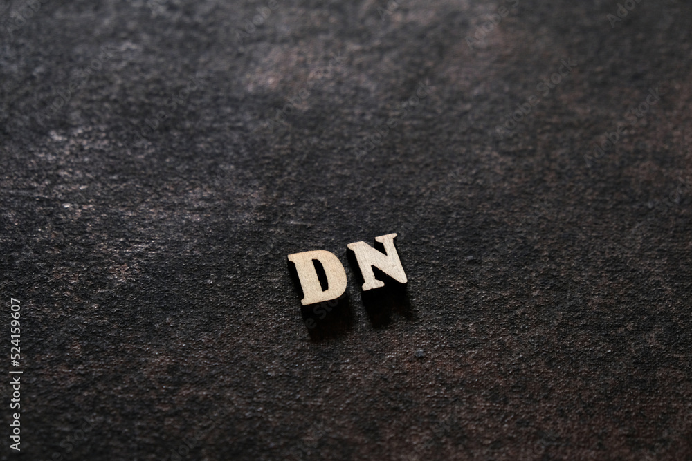 Fototapete the letters d and n above the dark field. initials dn