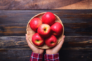 Red apple fruit in basket holding by hand, Healthy eating, Top view