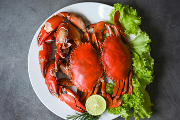 seafood plate with herbs spices rosemary lemon lime salad lettuce vegetable, fresh crab on white plate seafood, crab cooking food boiled or steamed crab on dark background