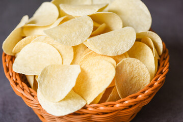 Crispy potato chips on the food table black background, Potato chips snack on basket