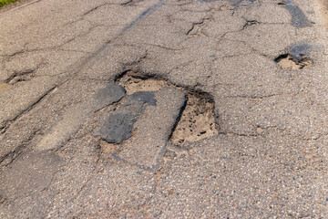 An old paved road with a lot of holes and damage © rsooll