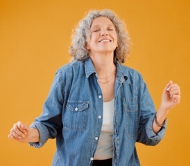 Smiling mature woman celebrating, dancing and being carefree, happy and excited for retirement. Portrait of positive, trendy and funky positive senior lady free spirit, dance and having fun in studio