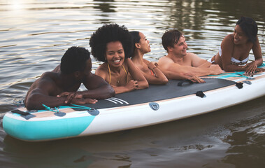Friends, swimming and summer break with paddle board in a lake, ocean or sea over holiday, vacation...