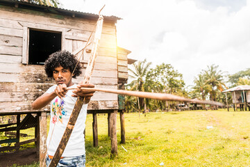 Afro-descendant latin teenager on the north caribbean coast of nicaragua taking aim with a bow and...
