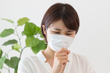 マスクをして咳をする女性