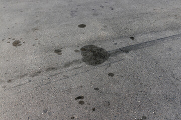 A road for vehicles covered with stains and pollution from oil and fuel of cars