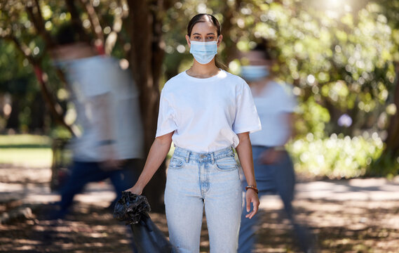 Woman In Covid Face Mask Cleaning The Park For Clean, Hygiene And Safe Green Environment. Responsible Activist, Volunteer Or Community Service Worker With Rubbish, Trash And Garbage In A Plastic Bag