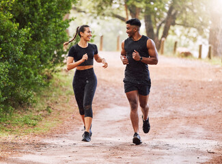 Fitness, exercise and happy couple out running or jogging on a forest trail or park outdoors....