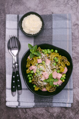Green pasta with peas, sausages and cheese