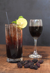 Highball mulberry wine cocktail and mulberry wine in glass on wooden table and black background