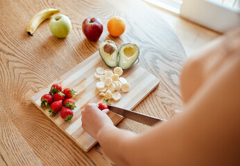 Health, diet and healthy woman cutting fruit to make a smoothie with nutrition for an organic meal at home. Closeup of caucasian female hands chopping fresh produce for a health in a kitchen.