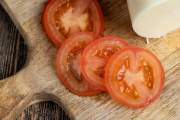 Cut the tomato into pieces while cooking the salad