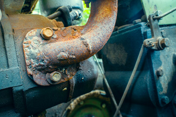 Mounting the exhaust pipe of a walk-behind tractor close-up. Rusty cooker exhaust pipe. The metal is corroded at the welding site