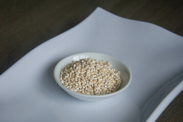 Bowl of organic pearl barley on white plate